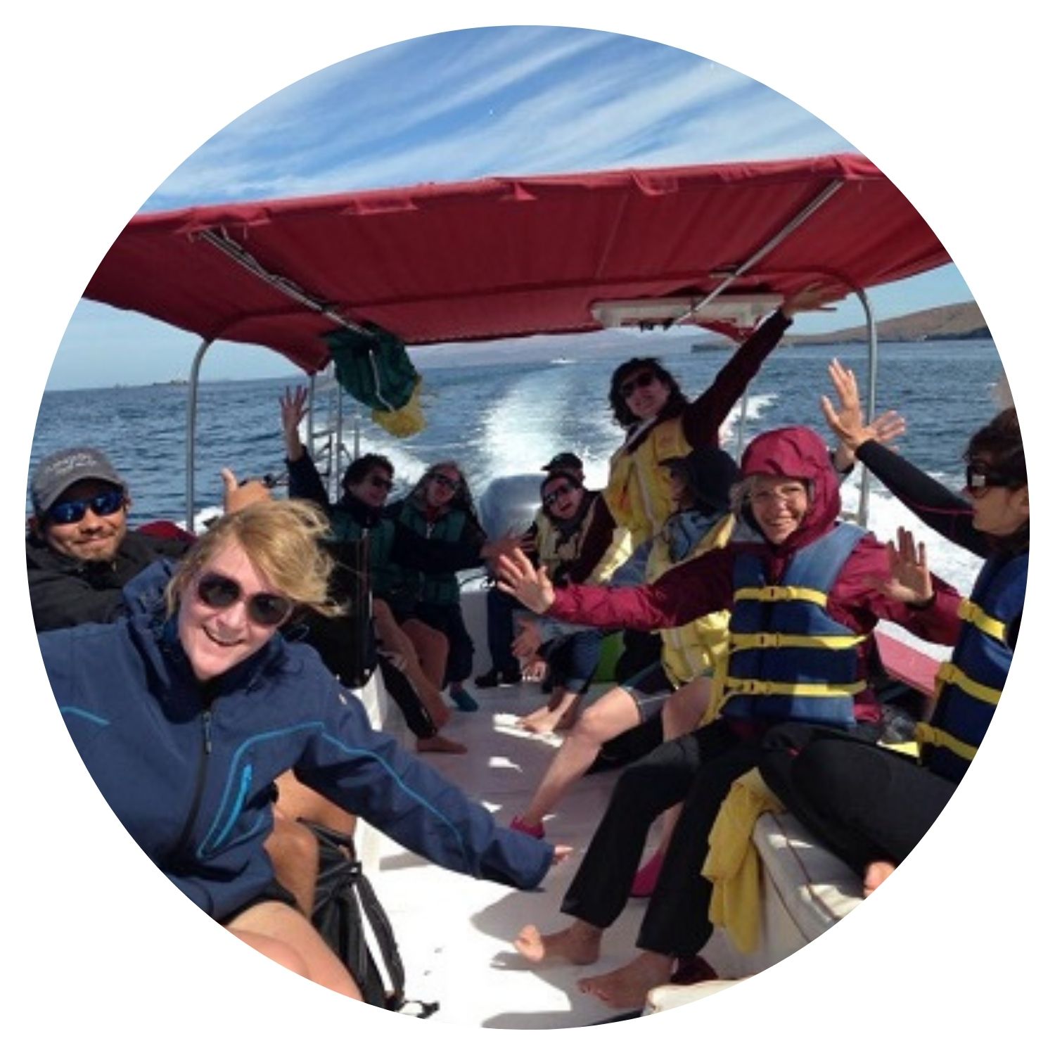 Groupe de personnes prenant une photo de groupe sur un bateau en mer, capturant leur joie lors d'une expérience unique en Basse-Californie.