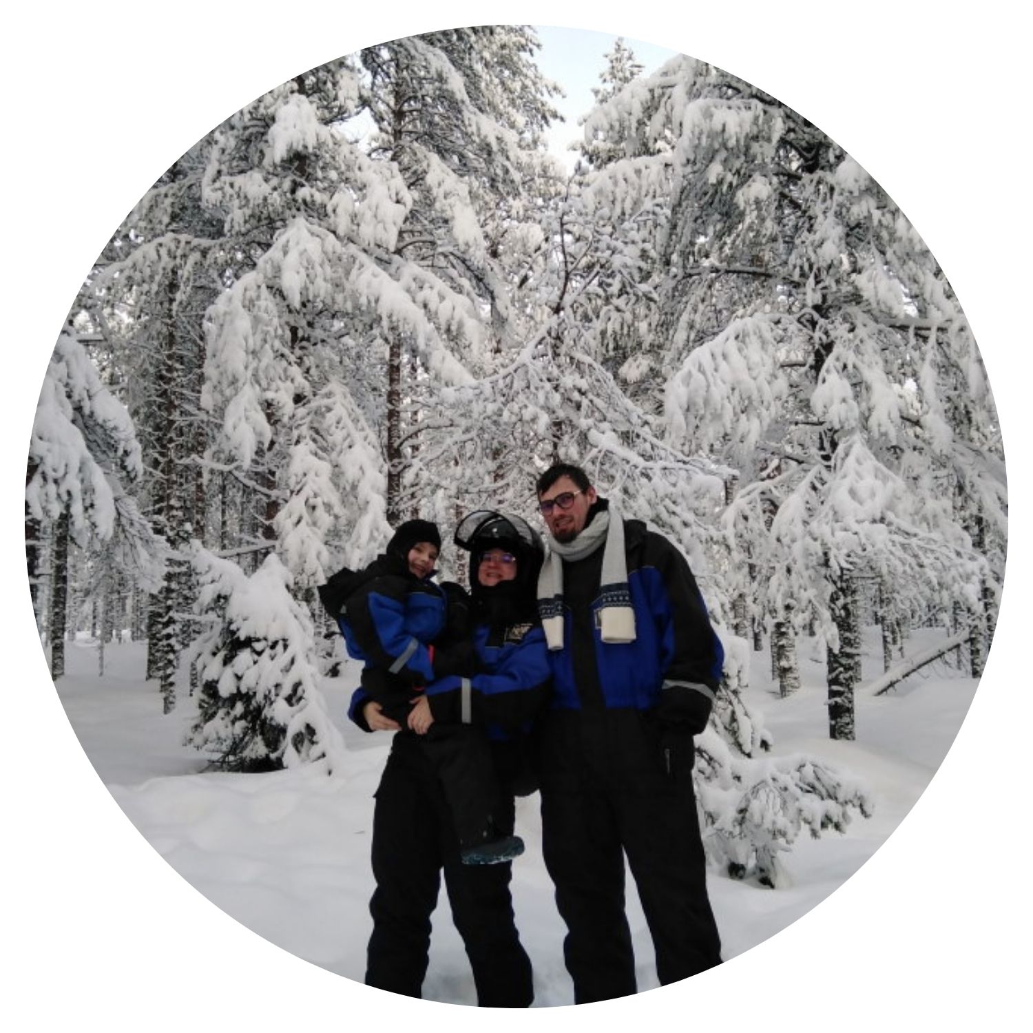 Une famille composée d'un petit garçon et ses parents prend une photo dans une magnifique forêt recouverte de neige en Finlande, capturant un moment de bonheur en pleine nature hivernale.