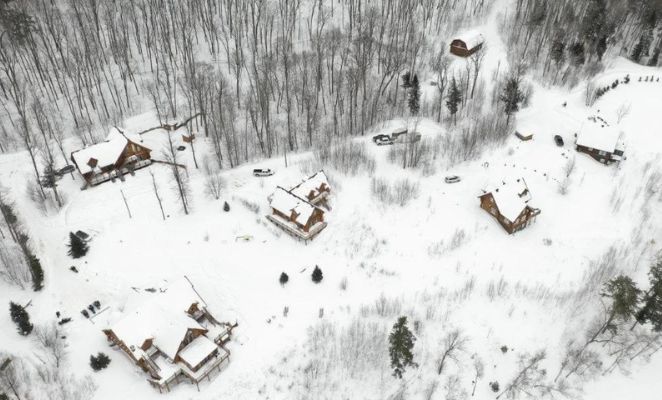 Vue aérienne d'un village enneigé entouré de forêt en hiver, au Canada