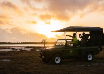 Jeep de safari au coucher du soleil avec des passagers observant le paysage à Zanzibar